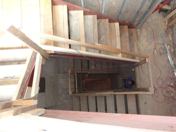 Looking down four flights of stairs in a browstone