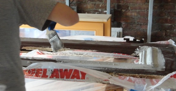 Putting on a thick paste to remove paint from old doors